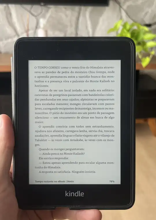 Leitor segurando um Kindle com uma página do livro Mate Seus Sonhos